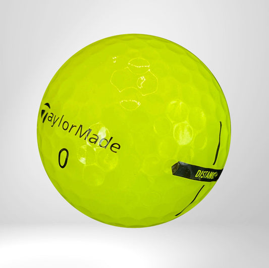Gelber TaylorMade Golfball mit Distance-Markierung auf weißem Hintergrund