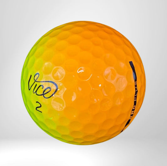 Zweifarbiger Golfball, gelb-orange und grün, mit Vice Logo auf weißem Hintergrund