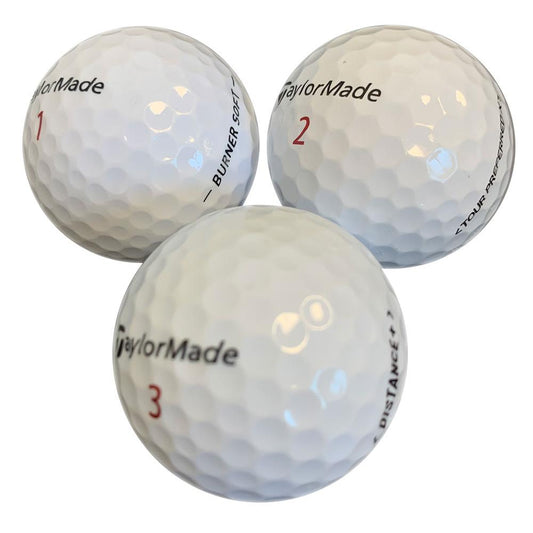 Drei weiße Golfbälle mit Nummern und Taylormade-Logo auf weißem Hintergrund