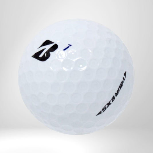 Weißer Golfball Bridgestone Tour B XS mit Logo, Nahaufnahme auf grauem Hintergrund
