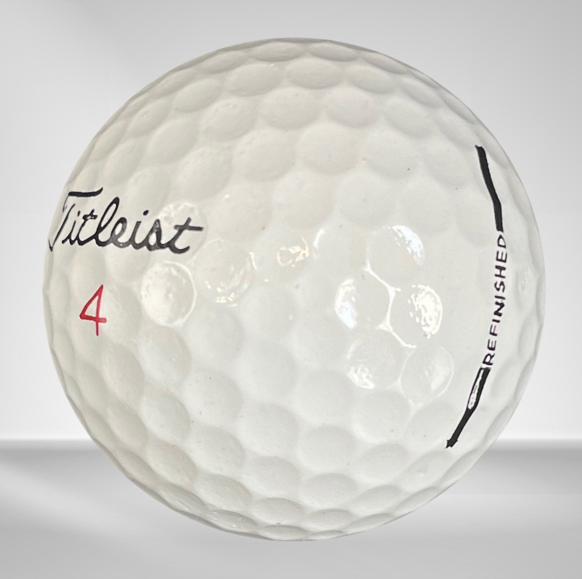 Weißer Titleist Golfball mit Nummer 4 und Refurbished-Aufdruck, Nahaufnahme