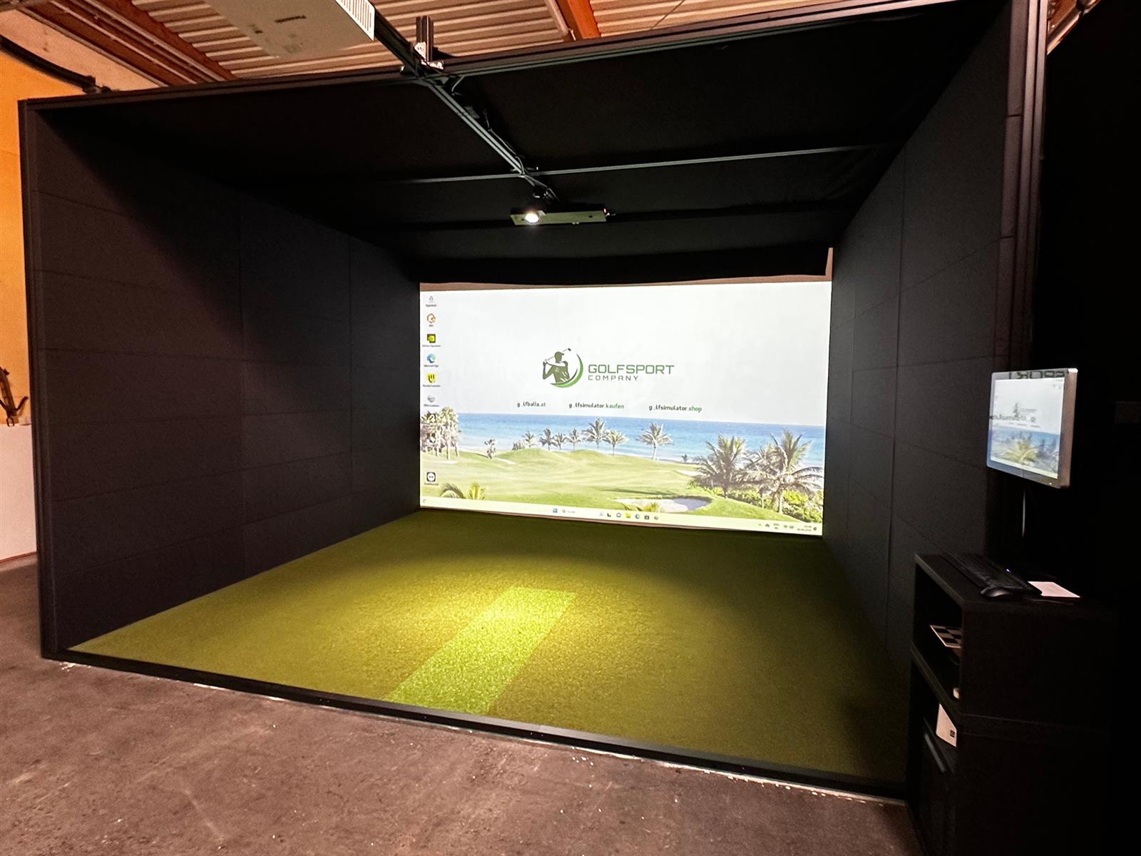 Moderner Golf Simulator mit großer Projektionsfläche und Kunstrasen in Indoor Umgebung