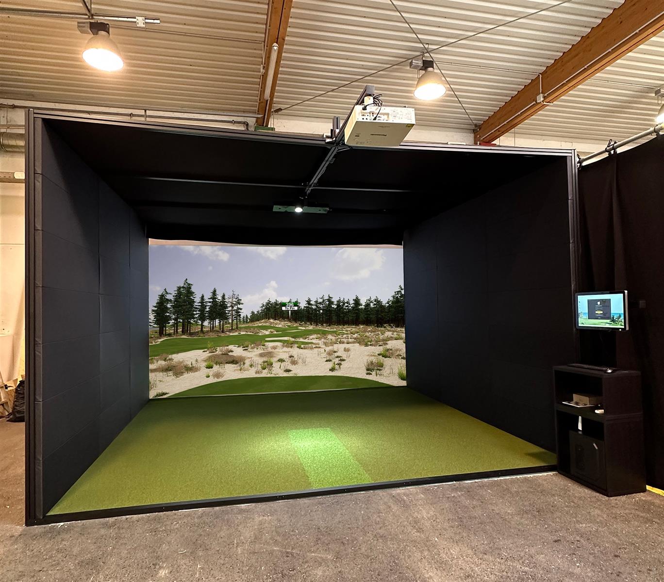 Moderner Indoor Golf Simulator mit projizierter Golflandschaft und Computersteuerung