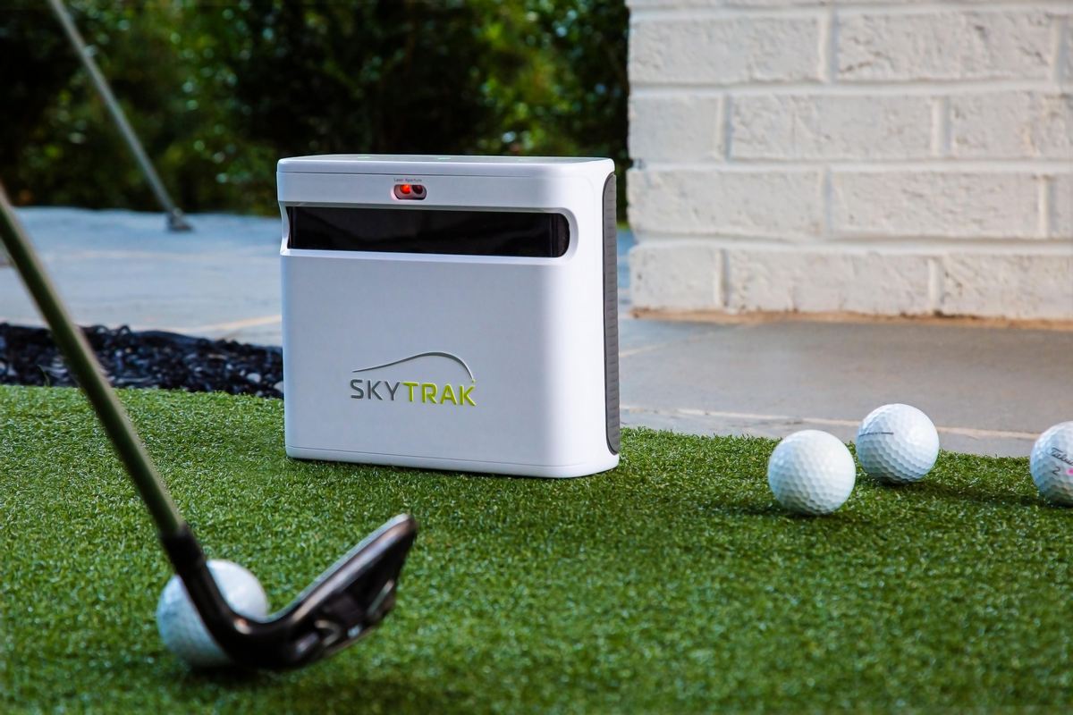 Golf Launch Monitor SkyTrak im Freien auf Kunstrasen mit Golfball und Golfschläger