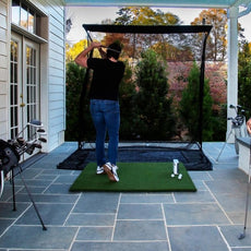 Golf Simulator Outdoor-Set mit Netz, Golfschläger und zwei Personen auf Terrasse
