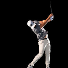 Golfer schlägt auf Indoor-Golfmatte mit Golf Simulator und Launch Monitor