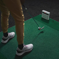 Golfer schlägt auf Indoor-Golfmatte mit Golfball und Launch Monitor, Golftraining Zubehör
