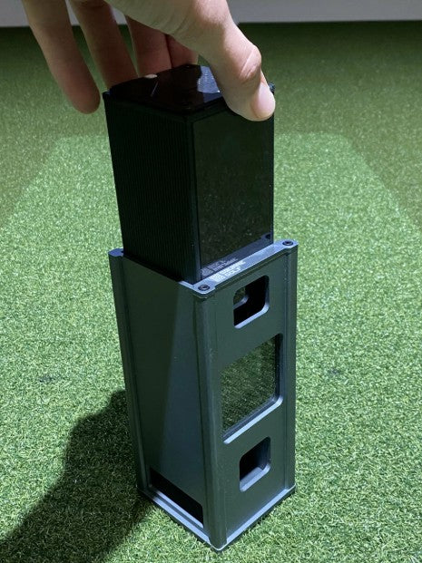 Golfball Aufbewahrungsbox auf Kunstrasen, Hand hält den Deckel, modern und kompakt