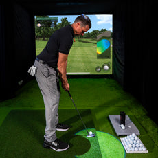Golfer beim Putten im Indoor Golf Simulator, mit Golfbällen und Zubehör auf Kunstrasen