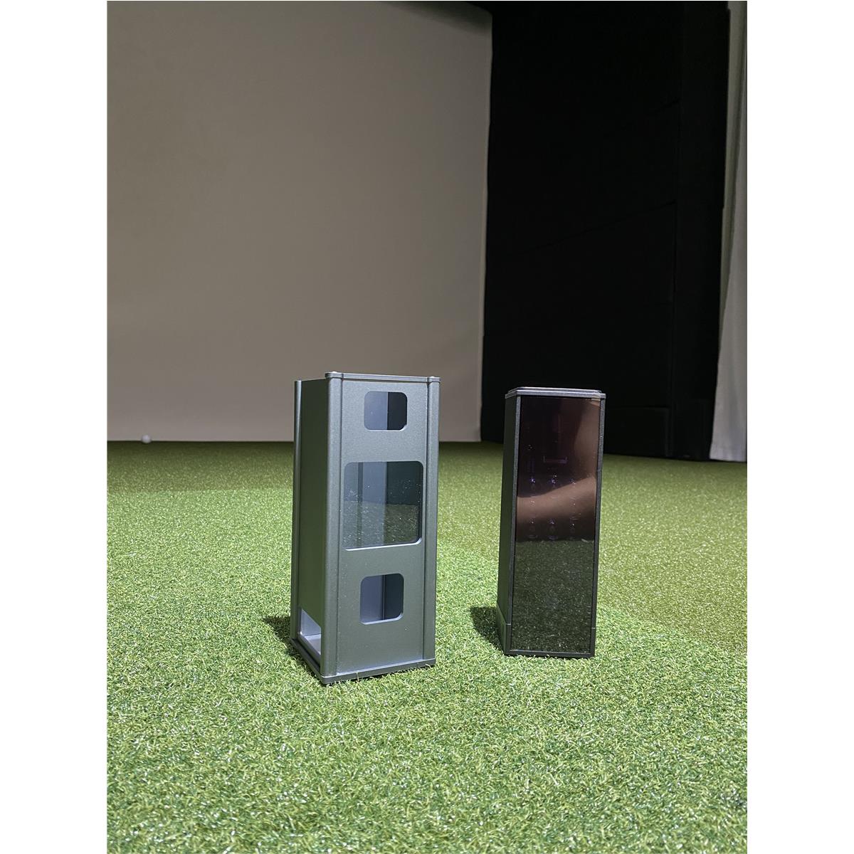 Zwei Golf-Simulator-Sensoren auf Indoor-Kunstrasen vor einer Leinwand