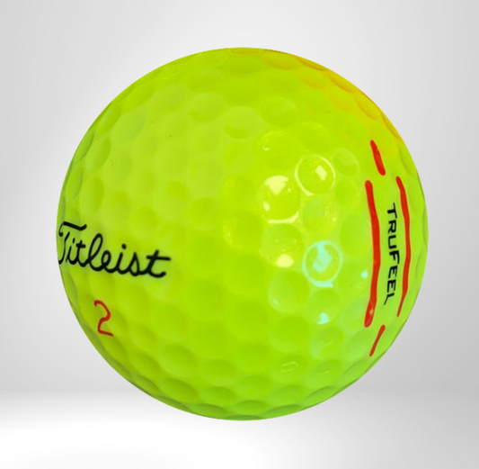 Leuchtgelber Golfball mit Schriftzügen Titleist und Trufeel, Nahaufnahme auf weißem Hintergrund.